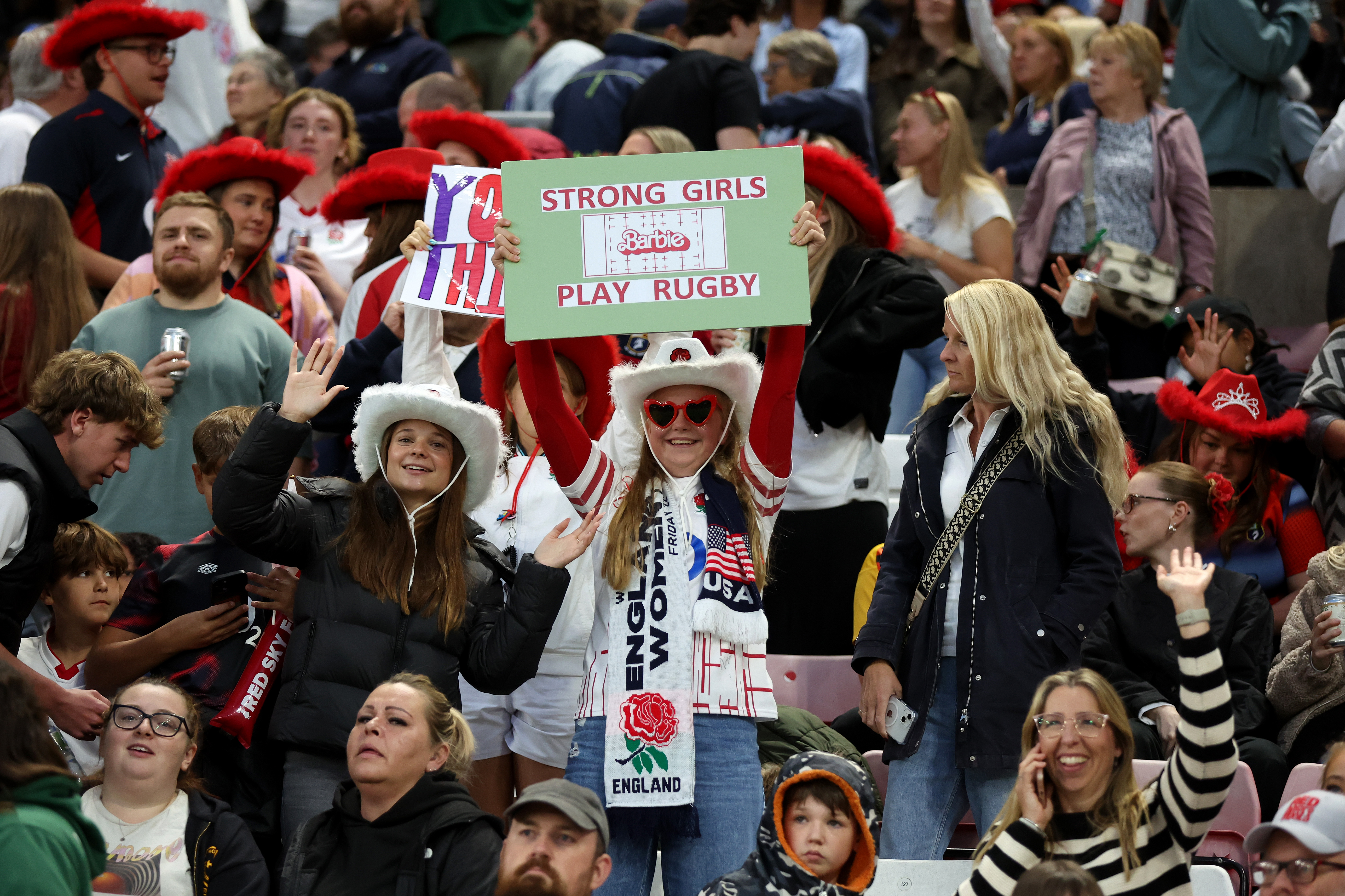 A fan holds a sign which reads 'strong girls play rugby' during the Women's Rugby World Cup 2025 Pool A match between England and USA at the Stadium of Light